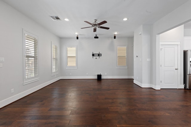 empty room featuring dark wood-style floors, recessed lighting, visible vents, and baseboards