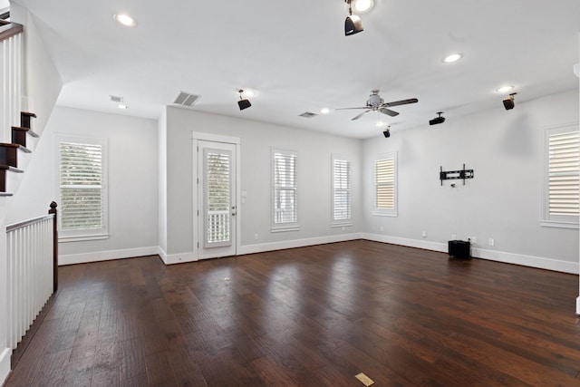 unfurnished room featuring dark wood-type flooring, a healthy amount of sunlight, visible vents, and baseboards