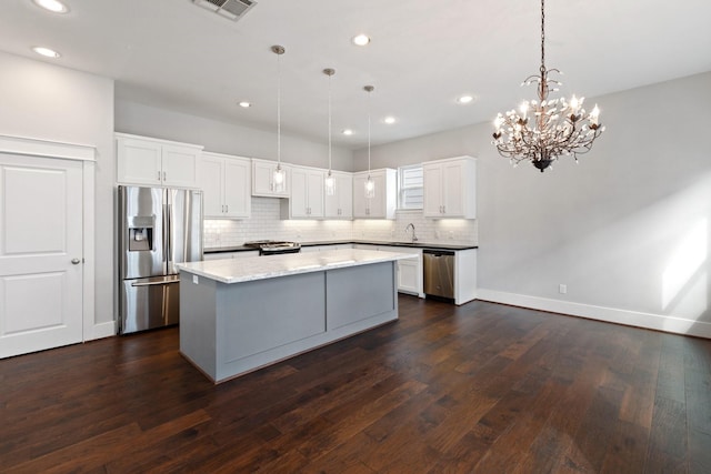 kitchen with stainless steel appliances, tasteful backsplash, dark wood-style flooring, and a center island