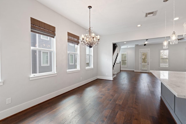 unfurnished dining area featuring dark wood-style floors, stairs, visible vents, and baseboards