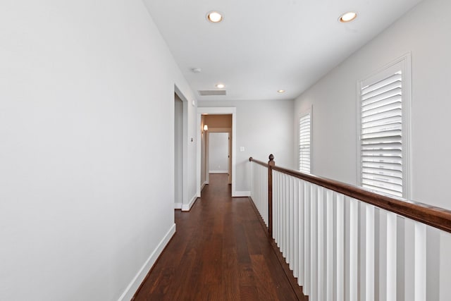 hallway with dark wood finished floors, recessed lighting, visible vents, an upstairs landing, and baseboards