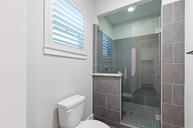 full bath featuring a stall shower and toilet