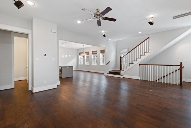 unfurnished living room featuring baseboards, visible vents, dark wood-type flooring, stairs, and recessed lighting