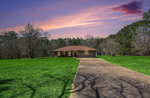 view of front of home with brick siding, an attached garage, concrete driveway, and a front lawn