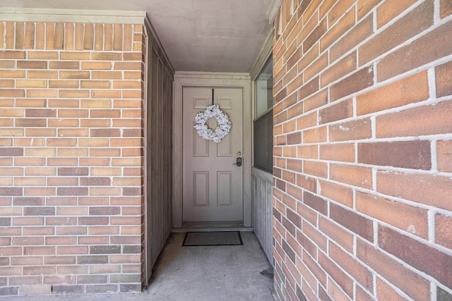 view of exterior entry with brick siding