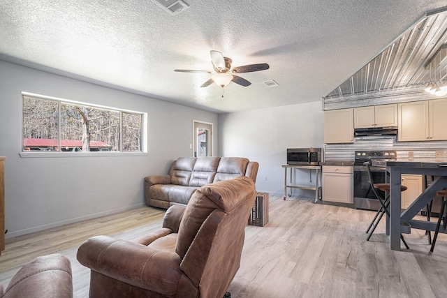 living area with baseboards, visible vents, light wood-type flooring, and ceiling fan