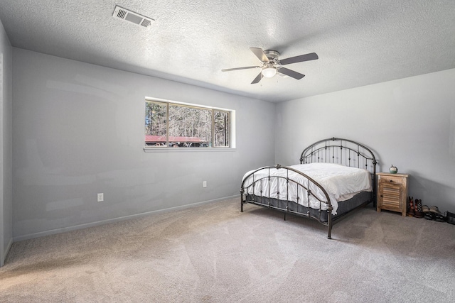 bedroom with visible vents, a textured ceiling, ceiling fan, and carpet floors