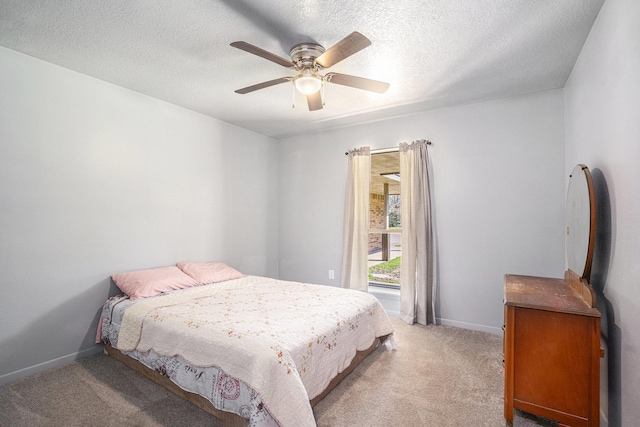 bedroom featuring baseboards, light carpet, and a textured ceiling