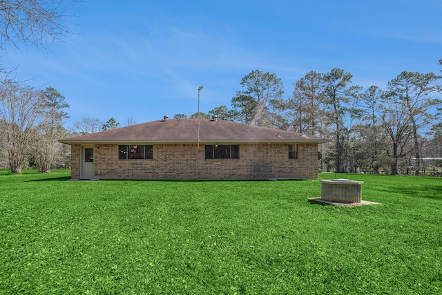 rear view of house with a yard and brick siding