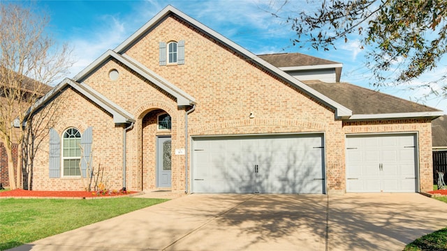 view of front of home with a garage, a front lawn, concrete driveway, and brick siding