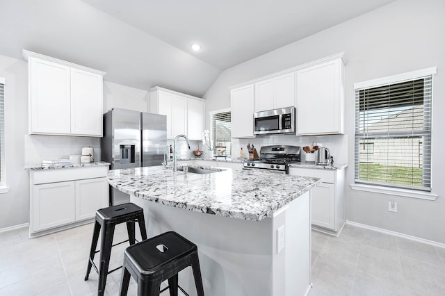 kitchen featuring stainless steel appliances, a breakfast bar area, a sink, and decorative backsplash