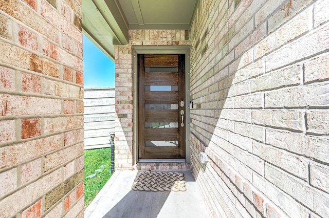 property entrance featuring brick siding