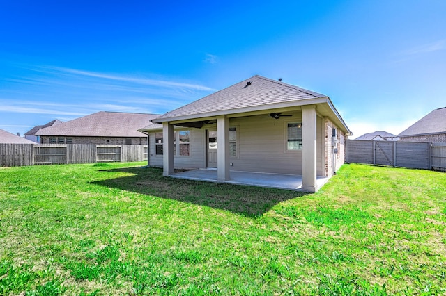 back of property featuring a lawn, a ceiling fan, a fenced backyard, roof with shingles, and a patio area