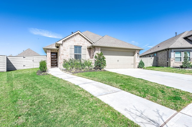 view of front facade featuring brick siding, an attached garage, a front yard, fence, and driveway