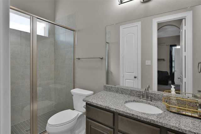 ensuite bathroom featuring ensuite bathroom, a shower stall, toilet, and vanity