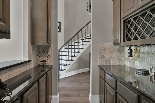 kitchen featuring dark wood-style floors, dark stone counters, and tasteful backsplash