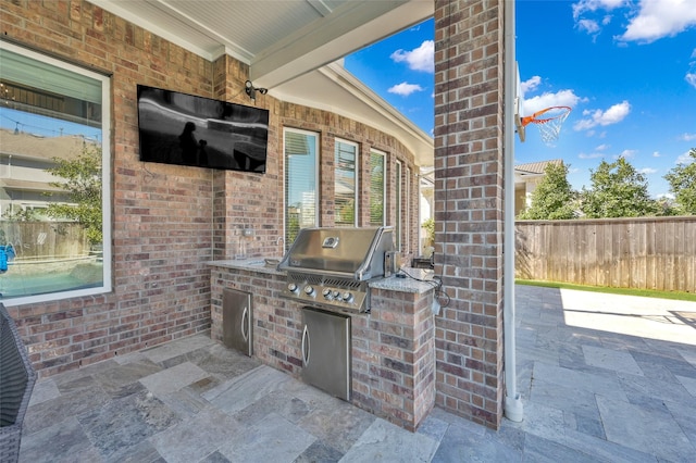 view of patio with area for grilling and fence