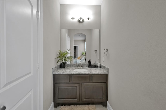 ensuite bathroom featuring vanity, baseboards, and ensuite bathroom