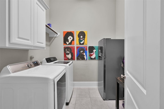 laundry area with washer and clothes dryer, light tile patterned flooring, cabinet space, and baseboards