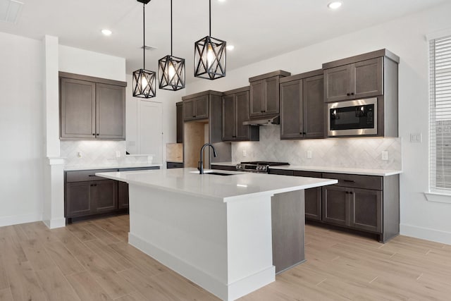 kitchen featuring dark brown cabinets, a sink, and built in microwave