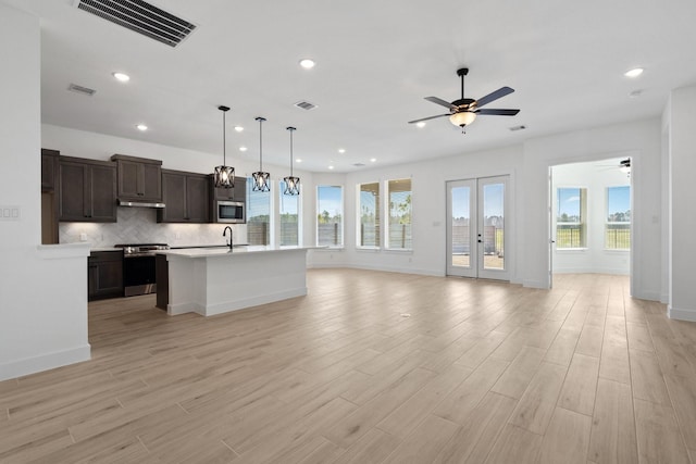 kitchen with appliances with stainless steel finishes, visible vents, open floor plan, and a sink