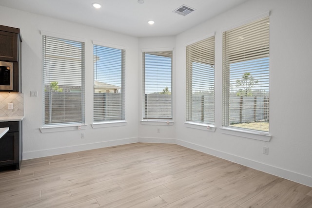 unfurnished dining area featuring recessed lighting, baseboards, visible vents, and light wood finished floors