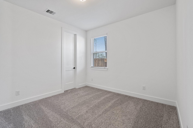 carpeted empty room featuring visible vents and baseboards