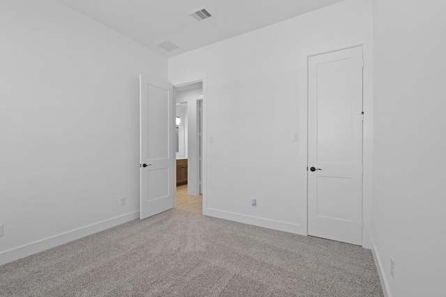 unfurnished bedroom with light carpet, baseboards, and visible vents