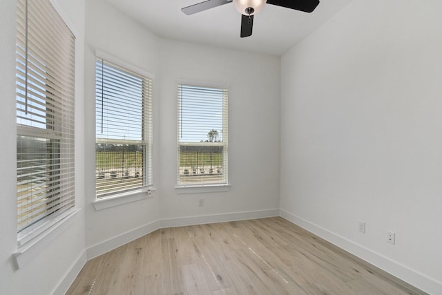 unfurnished room with ceiling fan, light wood-style flooring, and baseboards