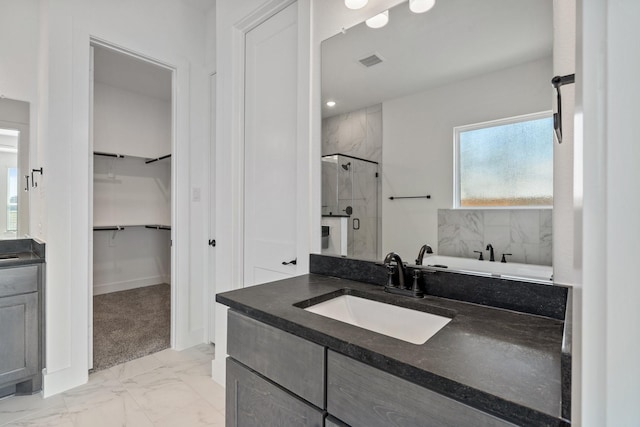 full bathroom with a walk in closet, marble finish floor, a marble finish shower, visible vents, and vanity