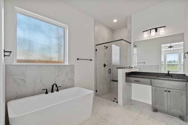 full bathroom with marble finish floor, recessed lighting, a freestanding bath, a shower stall, and vanity