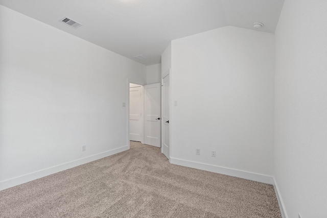 unfurnished bedroom featuring carpet floors, lofted ceiling, visible vents, and baseboards