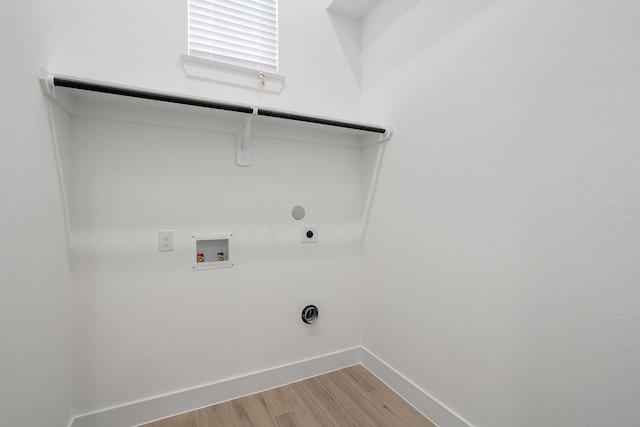 clothes washing area featuring laundry area, light wood finished floors, hookup for a gas dryer, washer hookup, and electric dryer hookup