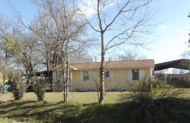 view of property exterior with a detached carport and a lawn