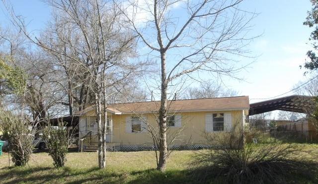 view of side of home featuring a detached carport and a yard