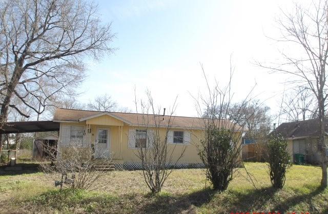 exterior space with an attached carport and a front yard