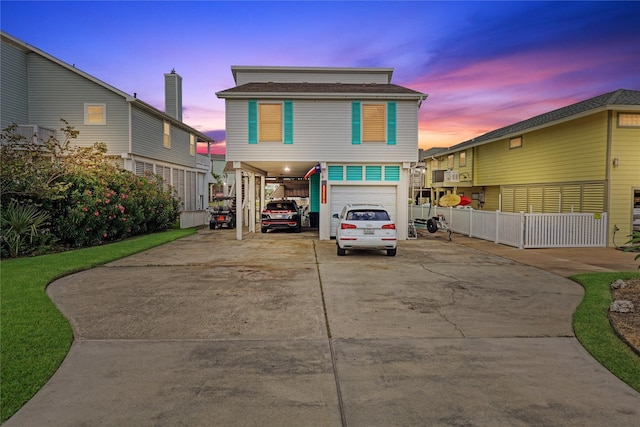 coastal home with a carport, driveway, and fence