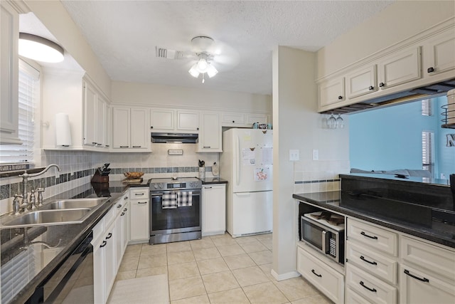 kitchen featuring stainless steel appliances, exhaust hood, a sink, visible vents, and dark countertops