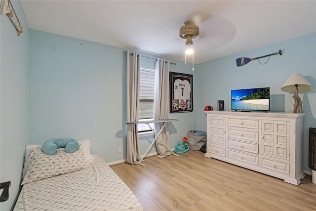 bedroom featuring light wood finished floors, ceiling fan, and baseboards