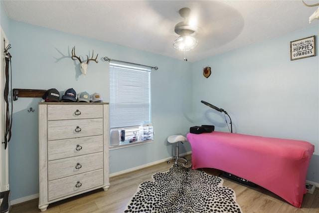 bedroom featuring ceiling fan, baseboards, and wood finished floors