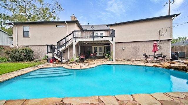 rear view of house featuring french doors, a patio, cooling unit, a wooden deck, and brick siding