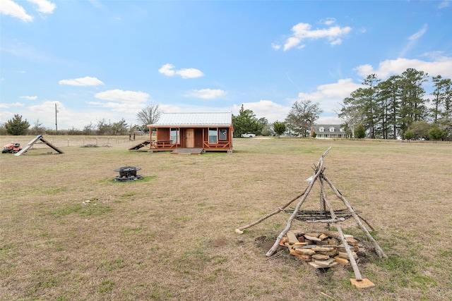 view of yard with an outdoor fire pit and an outdoor structure