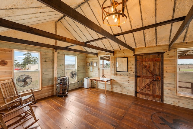 interior space with vaulted ceiling with beams, dark wood finished floors, and wooden walls