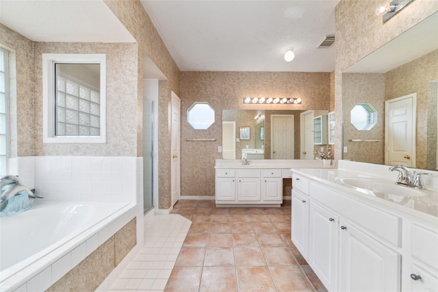 bathroom featuring a healthy amount of sunlight, wallpapered walls, visible vents, and a sink