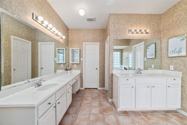 full bath with two vanities, a sink, visible vents, and wallpapered walls