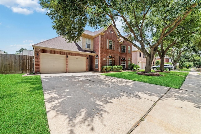 traditional-style house featuring an attached garage, brick siding, fence, driveway, and a front yard