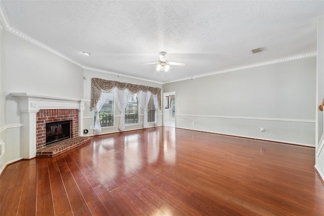 unfurnished living room with visible vents, ceiling fan, hardwood / wood-style floors, a textured ceiling, and a fireplace