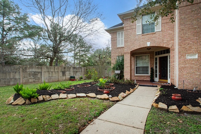 entrance to property with brick siding and fence