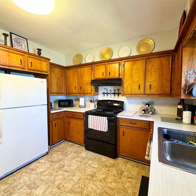 kitchen with brown cabinets, under cabinet range hood, light countertops, black appliances, and a sink