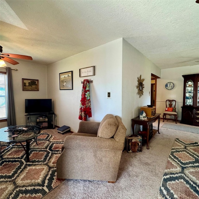 carpeted living room with a ceiling fan and a textured ceiling